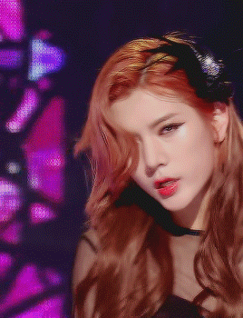a close up of a woman 's face with red hair and a black headband