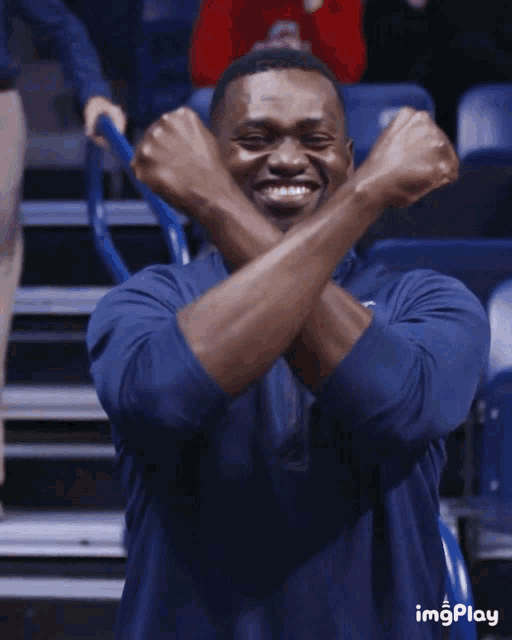 a man in a blue shirt has his arms crossed in a gif that says imgplay at the bottom