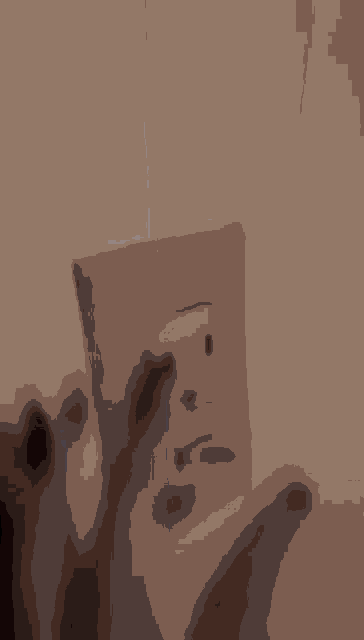 a close up of a brown wall with a shadow of a person standing in the background .
