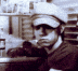 a man wearing a baseball cap and sunglasses is looking at the camera .
