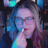 a woman wearing glasses and headphones is eating a piece of food