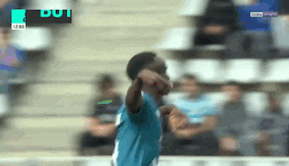 a soccer player is celebrating a goal in front of a crowd