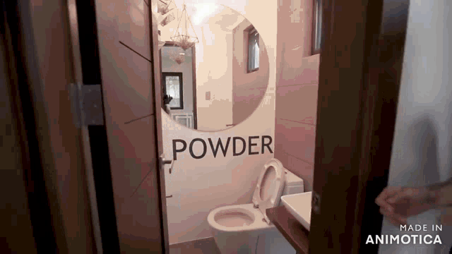 a bathroom with a toilet and a mirror that says powder