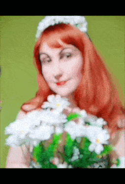 a woman with red hair holds a bouquet of white flowers