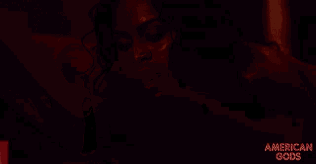a close up of a red candle with the words american gods above it