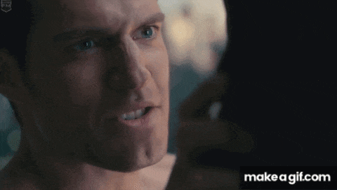 a close up of a man 's face with a serious look on his face in a dark room .