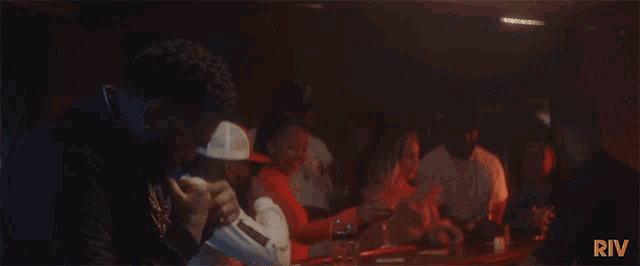 a group of people are sitting at a table with the word riv on the bottom