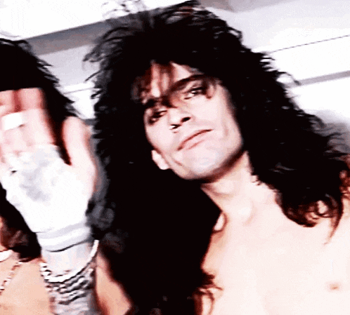 a close up of a man with long hair without a shirt on