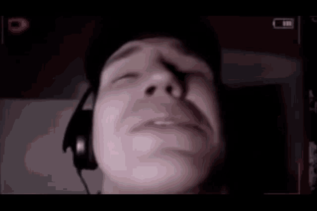 a close up of a person 's face with headphones on .