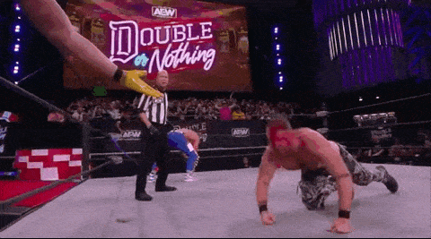 a wrestling match is taking place in a ring with a referee and a sign that says double or nothing .