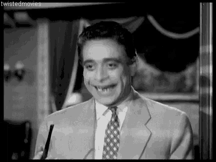 a man in a suit and tie is making a funny face .