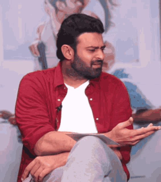 a man in a red shirt and white t-shirt is talking