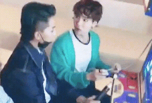 a couple of men are playing a video game together . one of the men is wearing a mask .