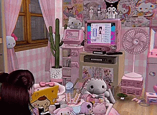 a girl is sitting in a pink room with a lot of stuffed animals and a computer .