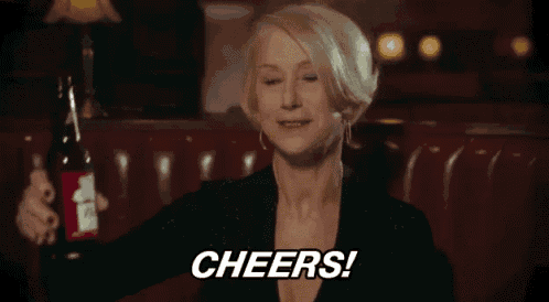 a woman is holding a bottle of beer and toasting with the words cheers .