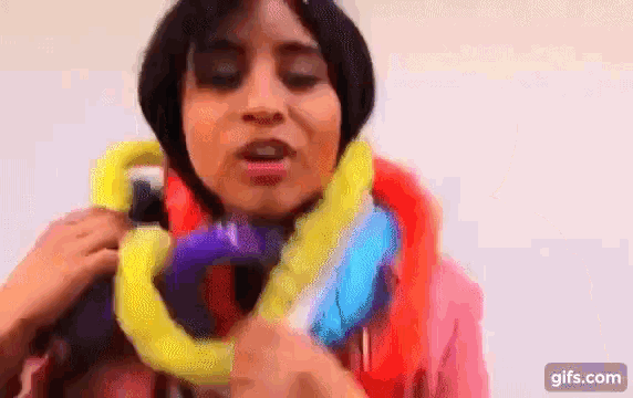 a woman is wearing a colorful scarf around her neck and holding balloons .
