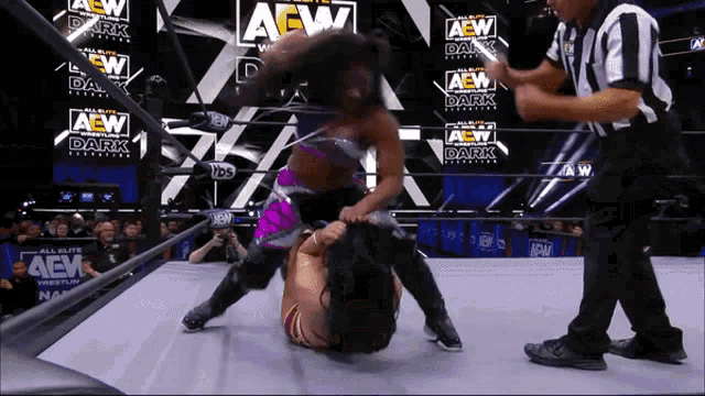 two women are wrestling in a ring that says aew on the wall
