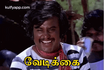 a man in a striped shirt is smiling and making a funny face in tamil .