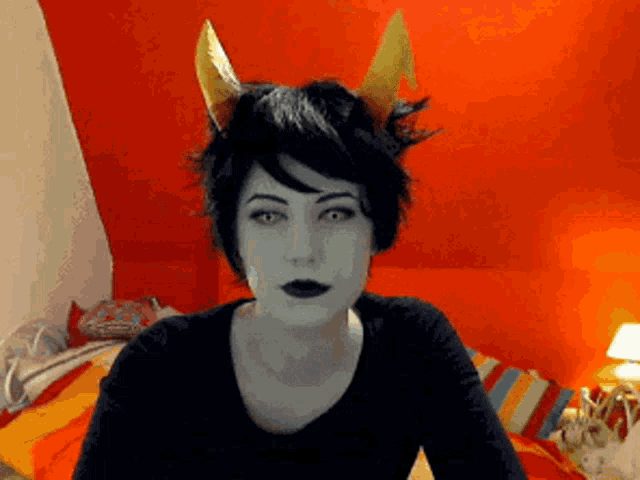a woman with horns on her head is wearing a black shirt