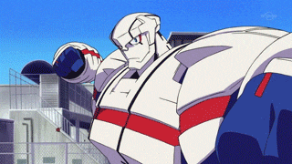 a robot is standing in front of a building with a blue sky in the background and a fence in the foreground