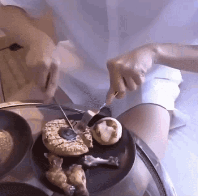 a person cutting a piece of cake with a knife and fork