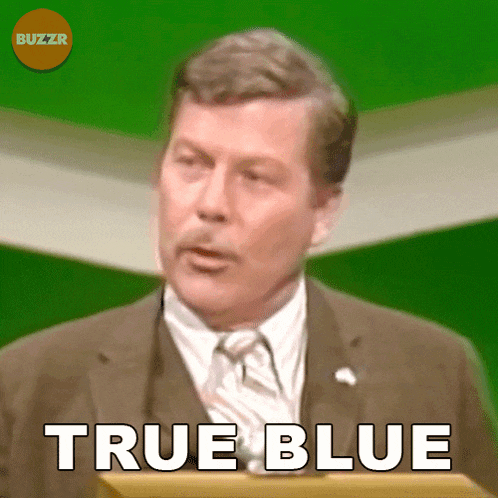 a man in a suit and tie is giving a speech and the words true blue are above him