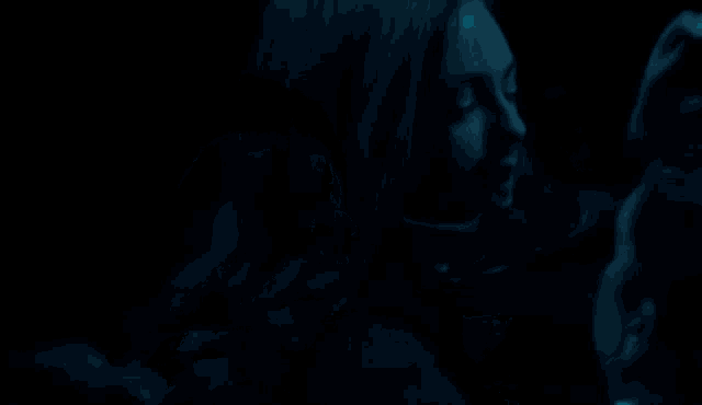 a man and woman are hugging each other in the dark .