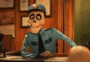 a skeleton police officer is sitting at a desk in a room .