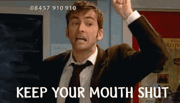 a man in a suit and tie is holding his fist in the air and says keep your mouth shut