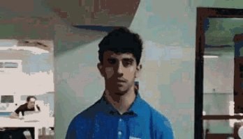 a man wearing a blue shirt that says ' abercrombie & fitch ' on the front