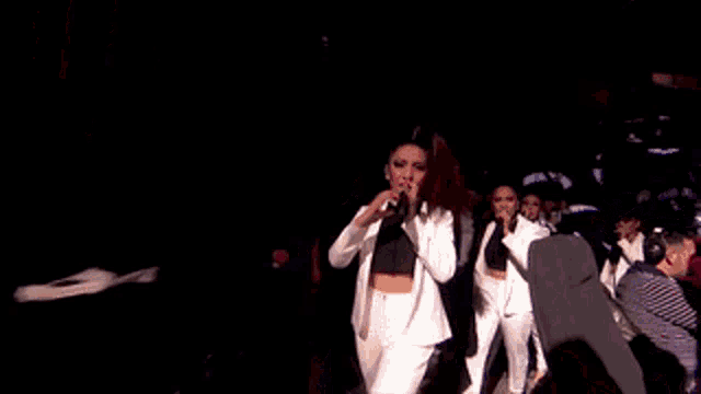 a woman singing into a microphone on a stage