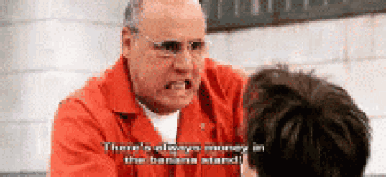 a man in a red jumpsuit is talking to another man in a prison cell .