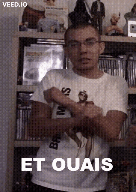 a man wearing a t-shirt that says " et ouais " stands with his arms crossed
