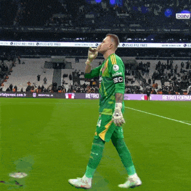 a soccer player walking on a field with a sign that says retro forma