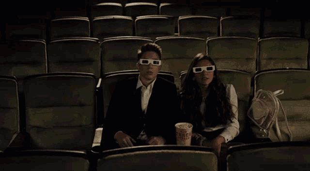 three people wearing 3d glasses are sitting in a theater