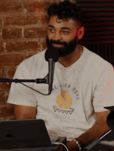 a man with a beard wearing a white t-shirt that says lion dore