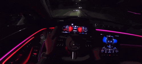 a person is driving a mercedes with a dashboard that has a lot of lights on it