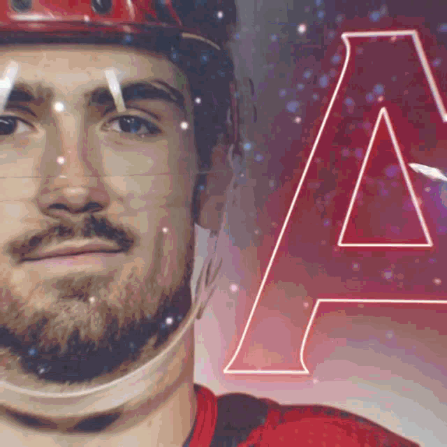a close up of a hockey player 's face with the letter a behind him