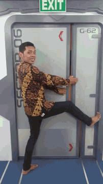 a man is leaning against a door that says exit