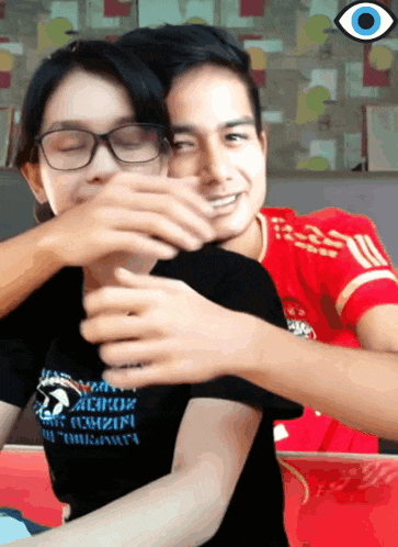 a man in a red shirt is hugging a woman in a black shirt that says across on it