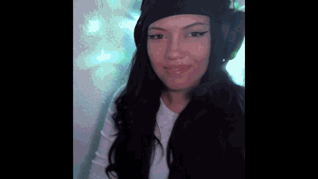a woman wearing headphones and a hat is making a funny face .