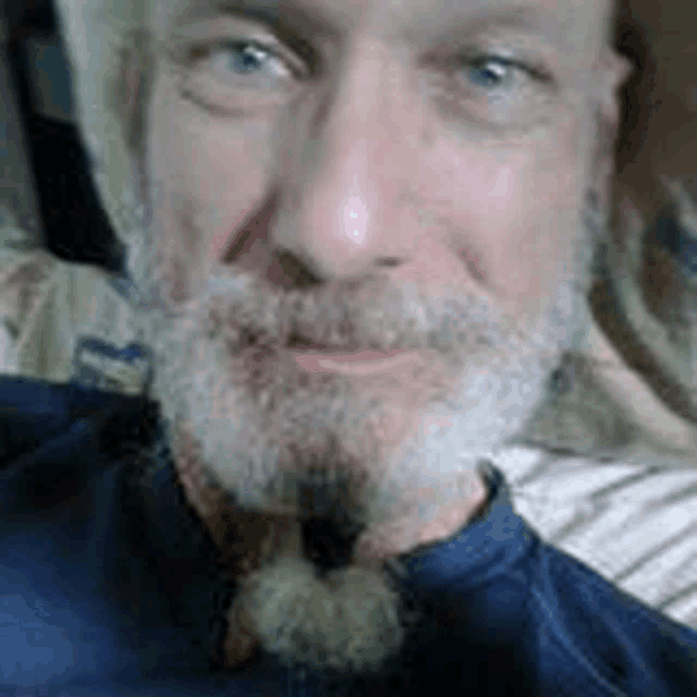 a close up of a man with a beard and hat .
