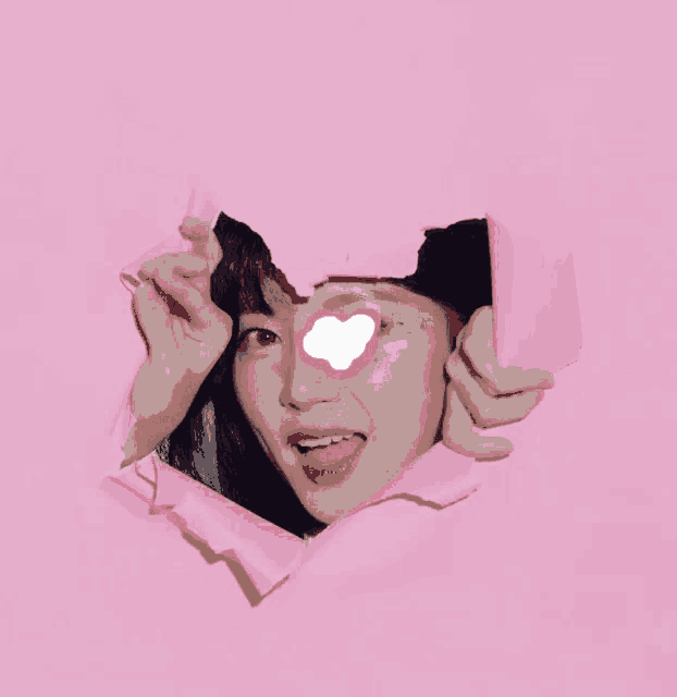 a woman is looking through a hole in a heart shaped frame