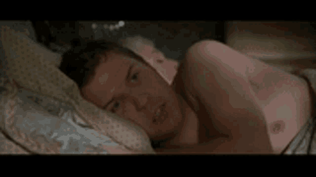 a man is sleeping in a bed with a woman .
