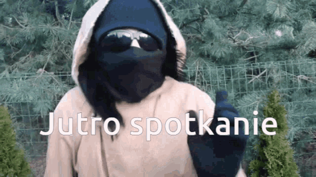 a person wearing a hooded jacket and sunglasses says jutro spotkanie in a foreign language