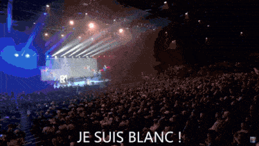 a man in a suit and tie speaking into a microphone with the words je suis blanc written below him