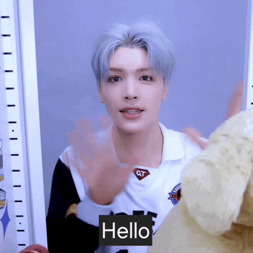a young man wearing a white shirt that says hello