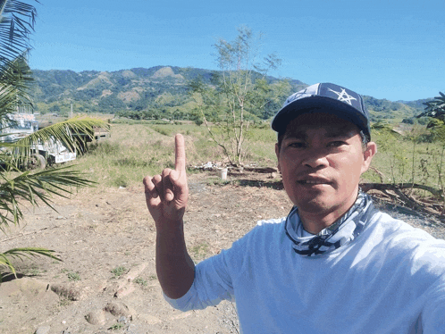 a man wearing a baseball cap with a star on it shows his middle finger