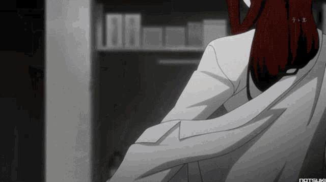 a woman in a white coat is standing in front of a bookshelf with the letters tb on the bottom right