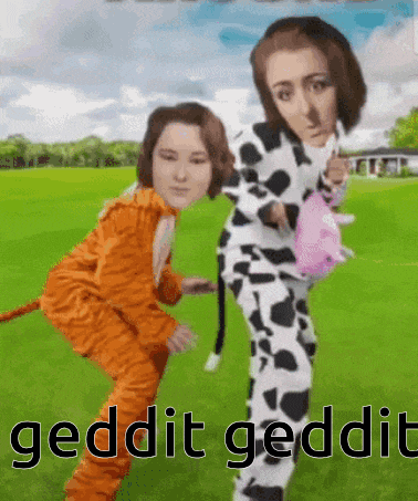two women in cow and tiger costumes are standing in a field
